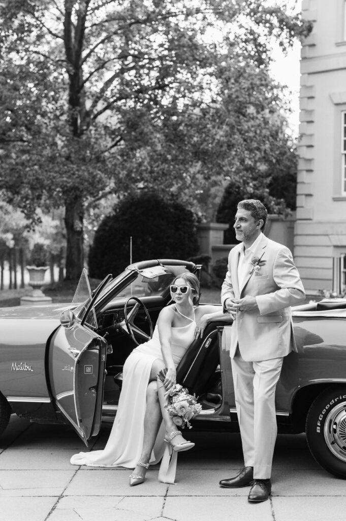 Bride and Groom look stylish while sitting in their vintage car outside of the Great Marsh Estate wedding venue
