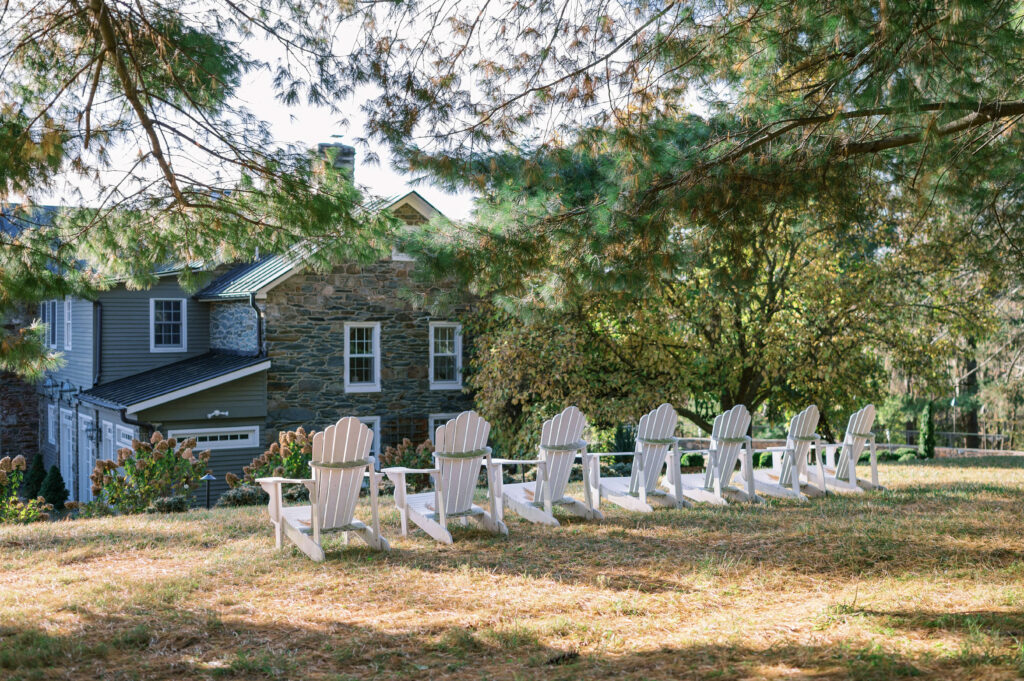 White chairs line up outside of the home and act as a nice lounge place for guests