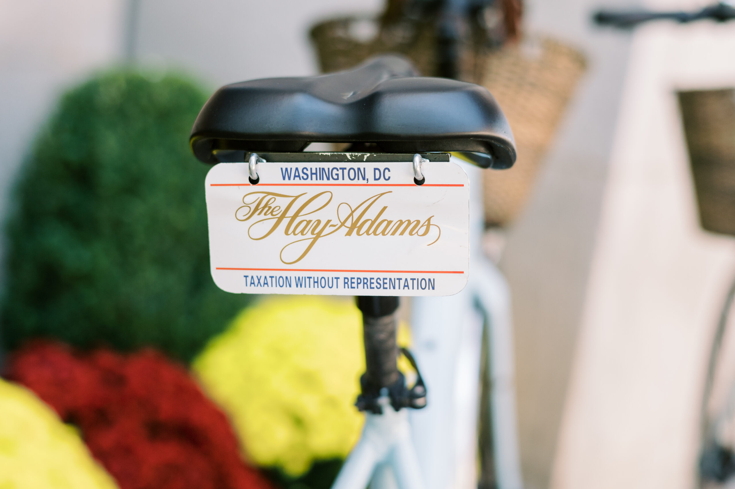 A blue rental bicycle sits outside of the Hay Adams Wedding venue and sports a license plate that says "Hay-Adams"