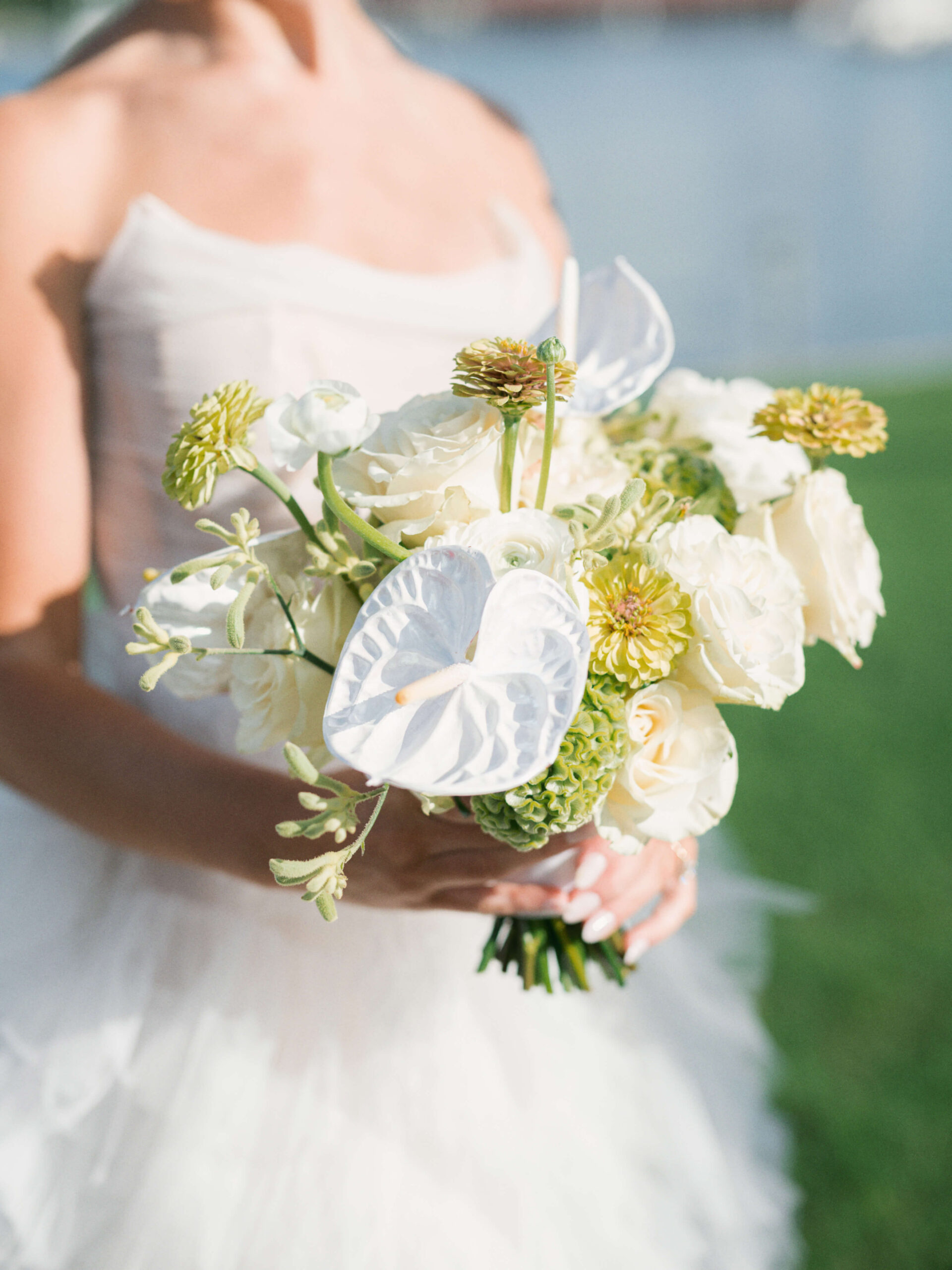 A bride holding a bouquet of white and green flowers at her Whitehall Wedding Venue